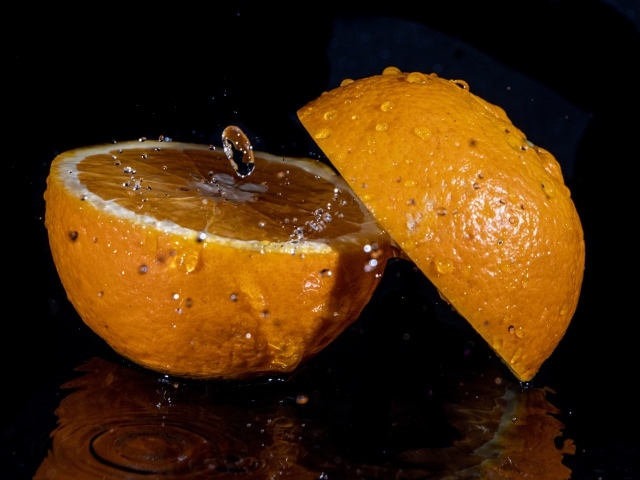 Две половины апельсина на черном фоне 