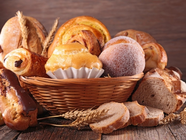 Свежая аппетитная выпечка в корзине на столе 