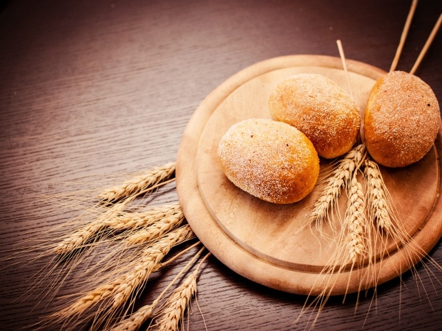 Свежий хлеб с колосьями пшеницы на доске