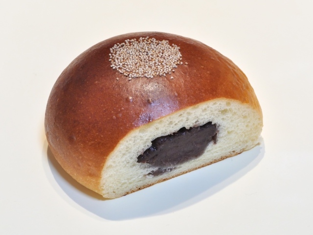 Свежая румяная булочка с вареньем на белом фоне