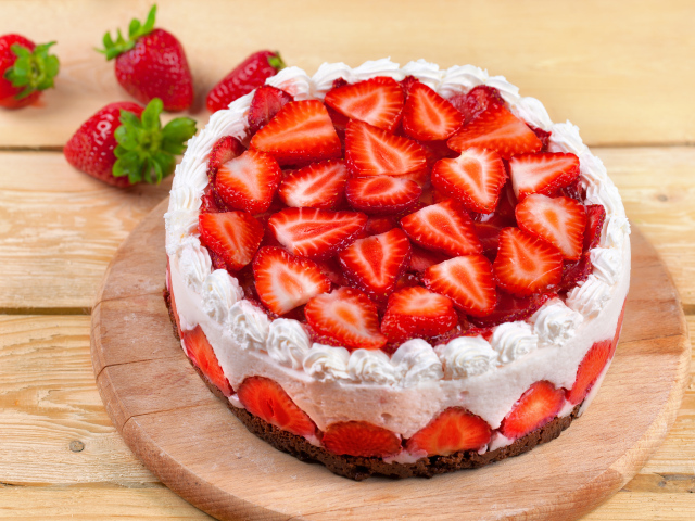 Красивый торт с кремом и ягодами клубники на доске