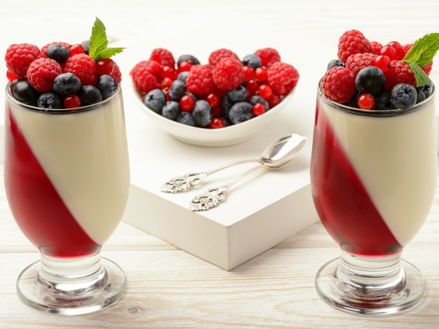 Двухцветный десерт с ягодами на столе 