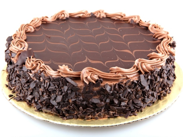 Большой праздничный торт с шоколадной крошкой на белом фоне