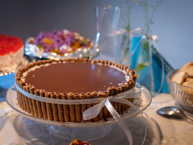 Большой шоколадный торт с трубочками на столе