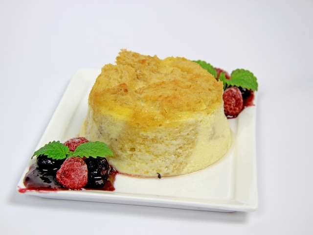 Пирожное на большой белой тарелке с ягодами