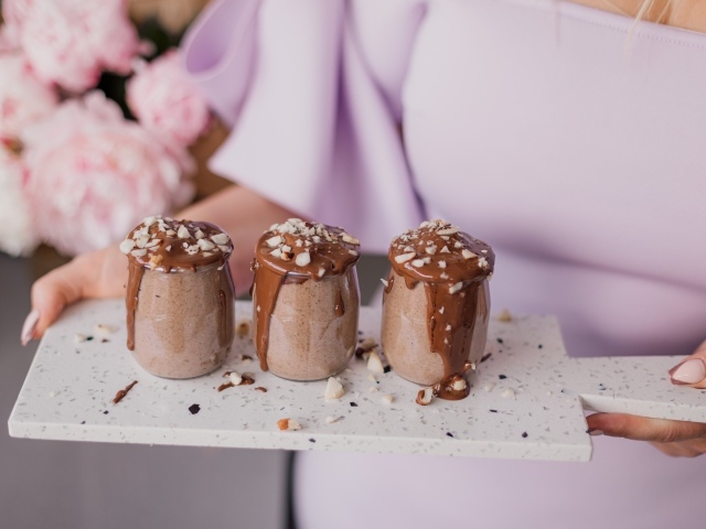 Шоколадный десерт в банках в руках у девушки