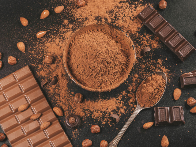 Какао на столе с орехами и плитками шоколада