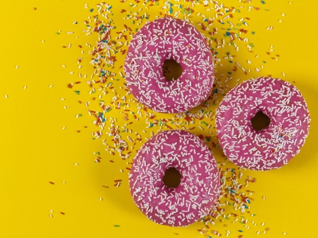 Пончики с розовой глазурью на желтом фоне