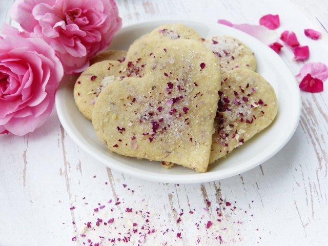 Песочное печенье в форме сердца в белой тарелке с цветами
