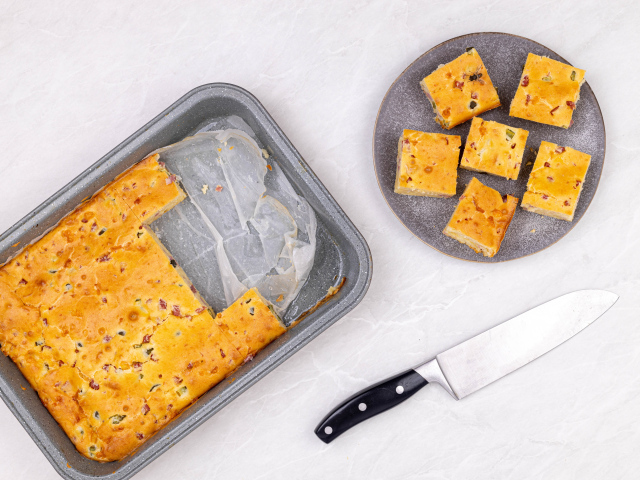 Пирог нарезан кусочками на столе с ножом