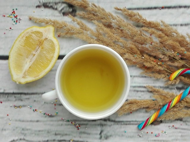 Чашка чая на столе с лимоном и колосьями