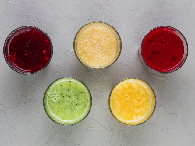 Стаканы с вкусным смузи на сером фоне