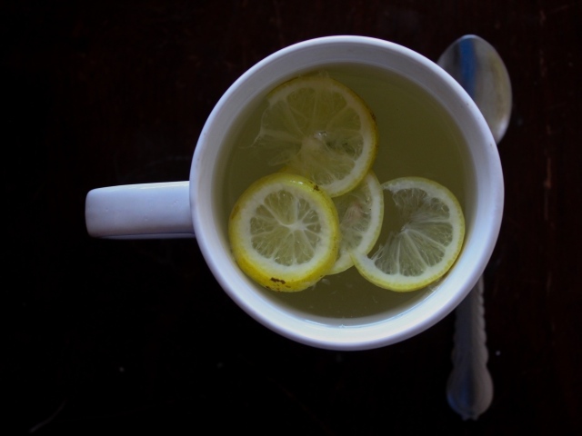 Зеленый чай с лимоном на черном фоне