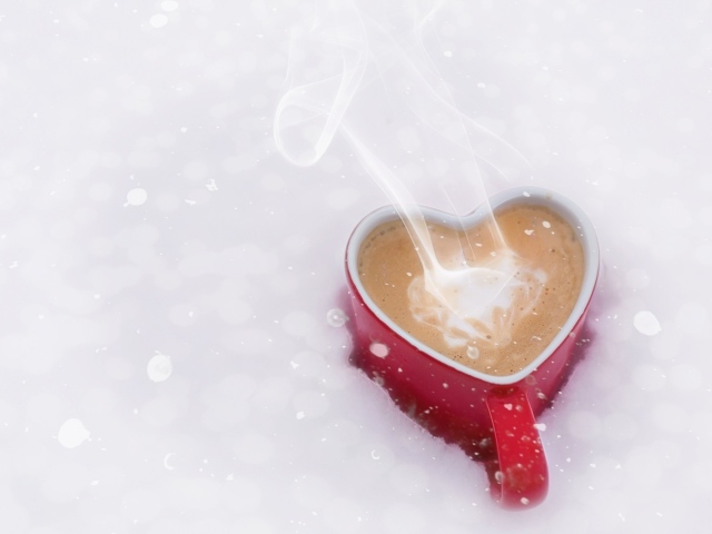Красная чашка в форме сердца с кофе на снегу