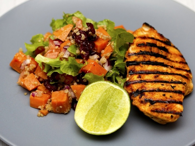 Запеченная куриная грудка с овощами и лаймом на тарелке 