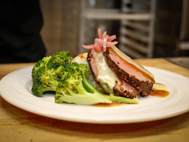 Брокколи на тарелке с кусочками запеченного мяса 