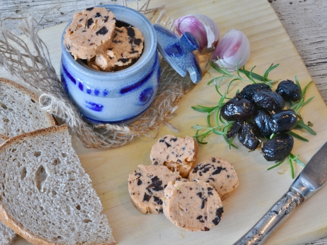 Колбаса с маслинами на столе с хлебом и чесноком