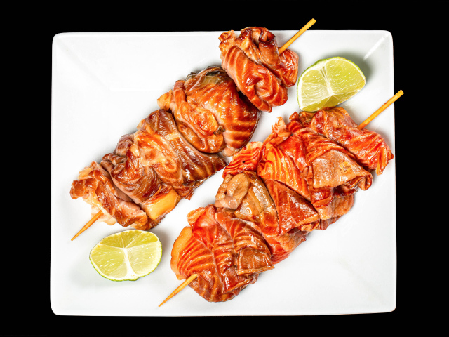 Шашлык на шпажках на белой тарелке с лимоном