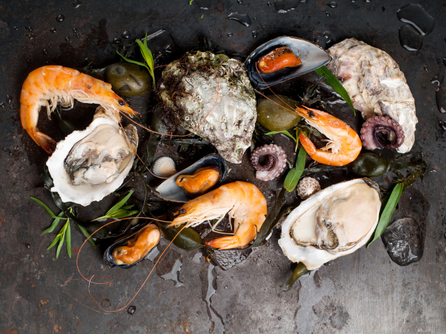 Мидии и креветки на черном столе 