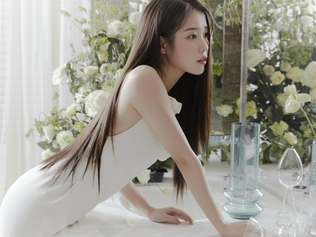 Красивая девушка азиатка в белом платье стоит у зеркала