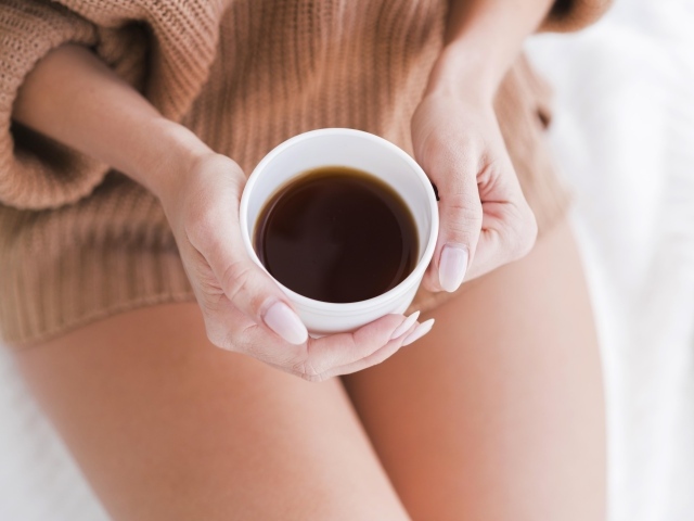 Чашка горячего кофе в руках у девушки 