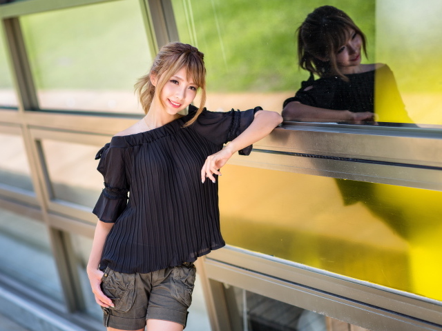 Девушка азиатка в черной блузке у окна