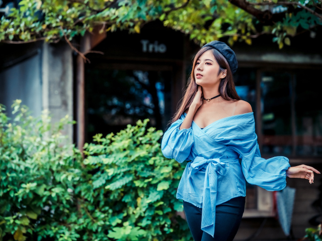 Девушка азиатка в синей рубашке и черном берете