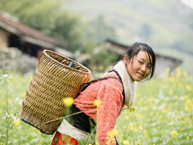 Девушка азиатка с корзиной на поле 