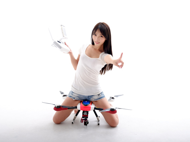 Девушка азиатка с квадрокоптером на белом фоне