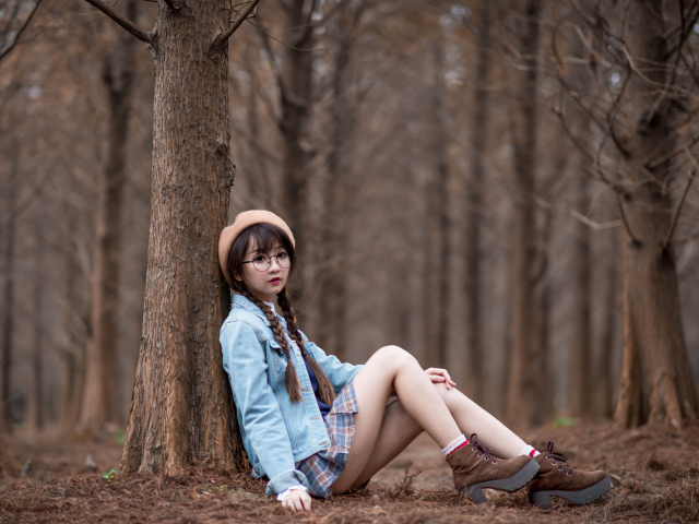 Девушка азиатка школьница сидит под деревом
