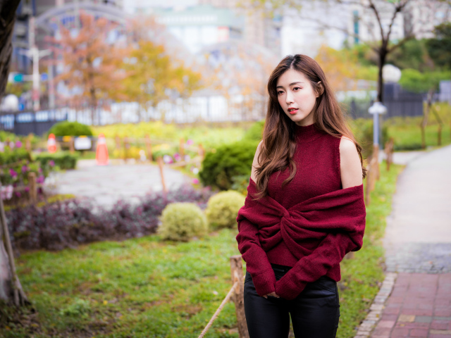 Красивая девушка азиатка в красном наряде в парке