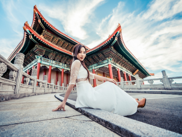 Красивая азиатка в белом платье на фоне храма