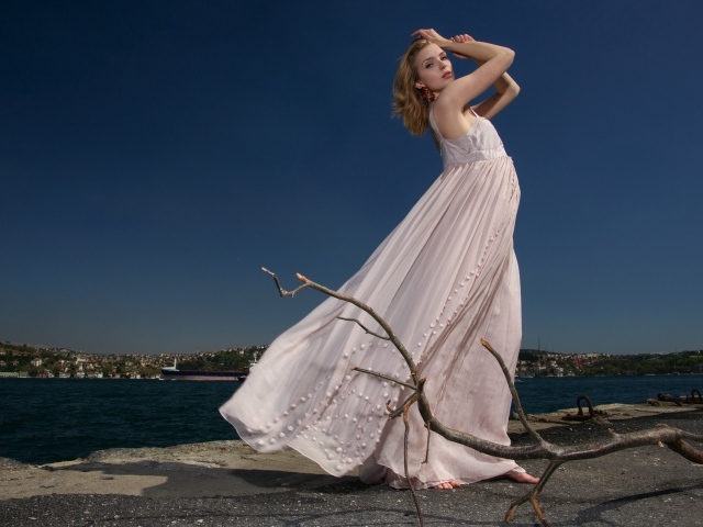 Красивая девушка в белом платье на берегу реки