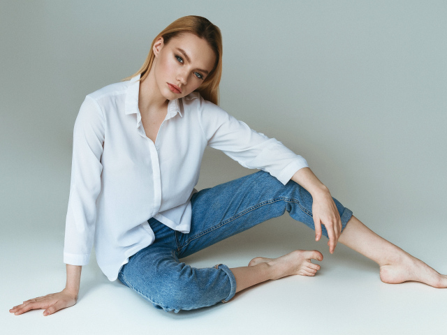 Красивая девушка в белой рубашке на сером фоне