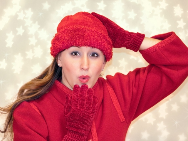 Красивая девушка в красном шлет воздушный поцелуй