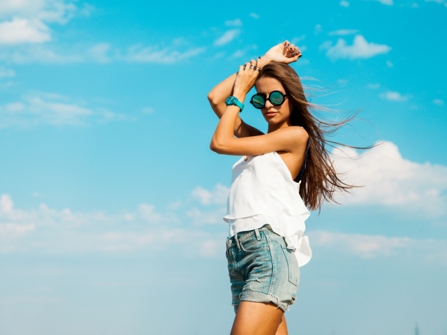 Красивая девушка в шортах на фоне неба
