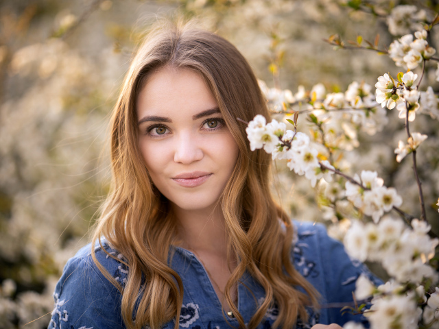 Красивая девушка у ветки с белыми цветами