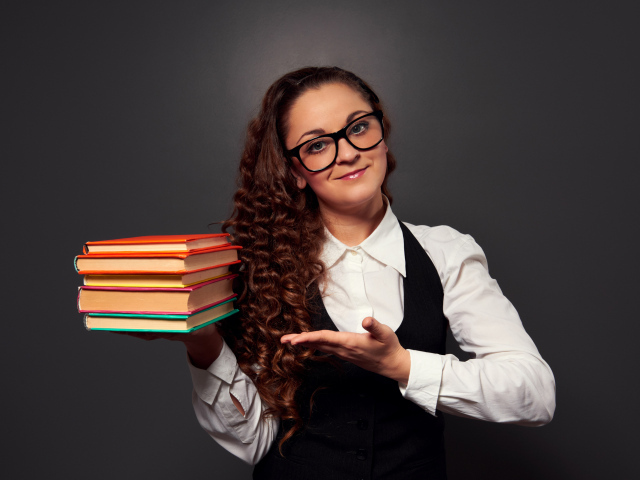Красивая девушка учитель в очках с книгами в руке