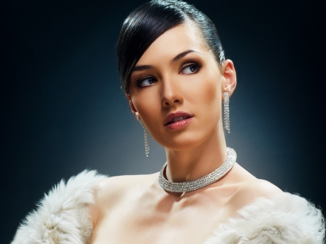 Красивая девушка с дорогими украшениями на черном фоне