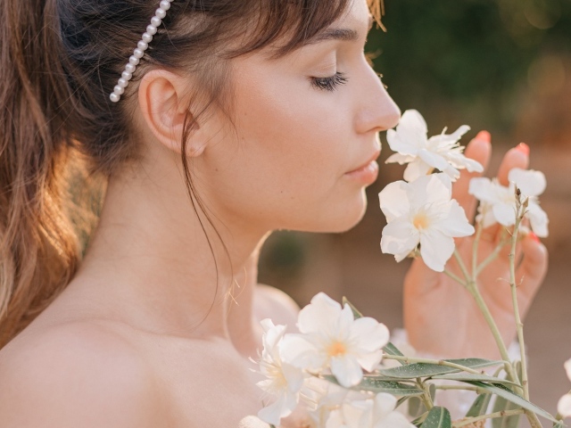Красивая девушка с белыми цветами в руке
