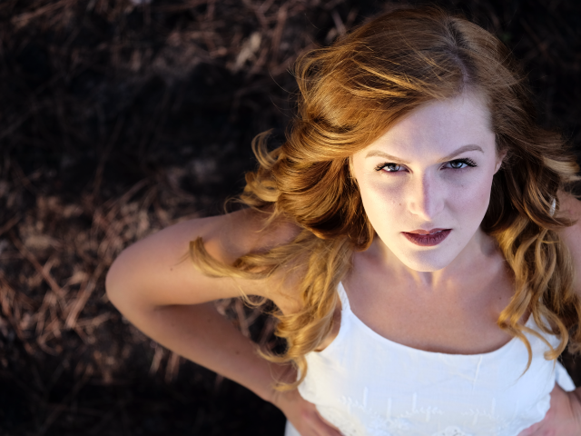 Красивый взгляд рыжеволосой девушки в белом платье