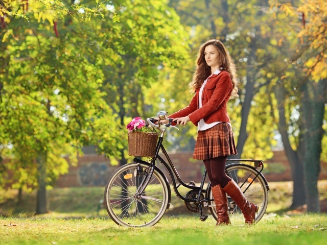 Красивая молодая девушка на велосипеде в парке 