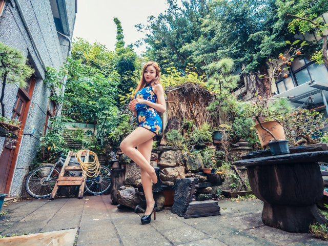 Милая азиатка в коротком платье у дома 