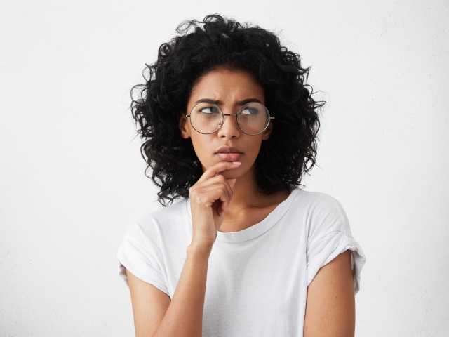 Темноволосая девушка в очках на сером фоне