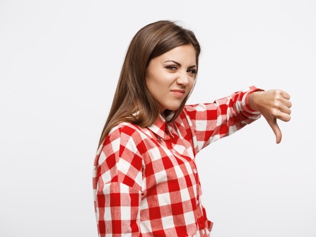 Недовольная девушка опустила палец вниз 