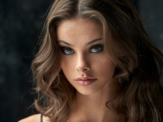 Лицо красивой девушки с веснушками на лице 