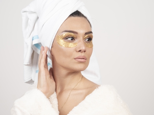 Девушка после душа с золотыми патчами под глазами