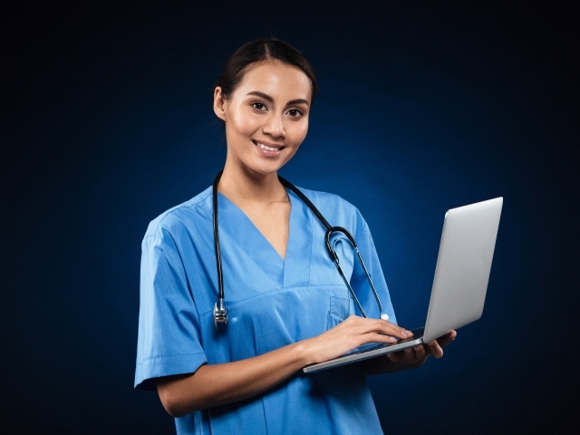 Девушка врач с ноутбуком на синем фоне 