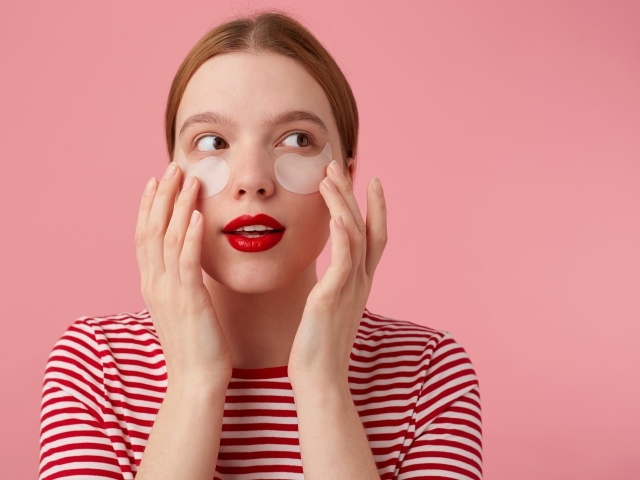 Девушка приклеивает патчи для глаз на лицо 