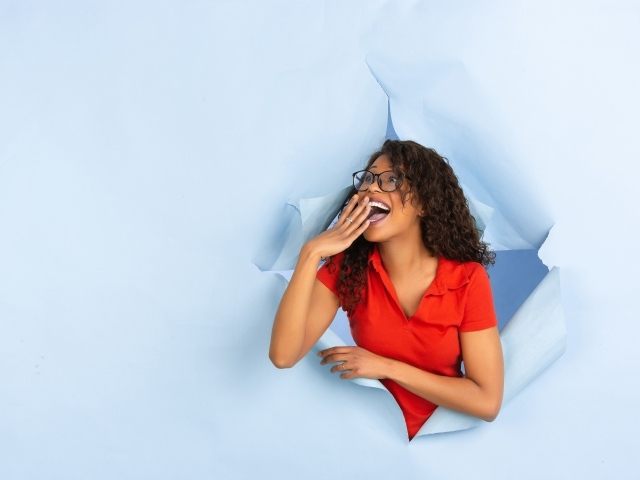 Радостная девушка прорвала дыру в стене